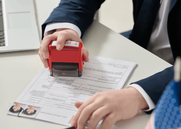 A translator stamps a certified birth certificate in a Pittsburgh office, providing Spanish Translation Services for agency.