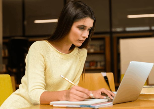 A linguist reviews a Russian technical manual on a laptop, using Russian Translation Services in Pittsburgh.